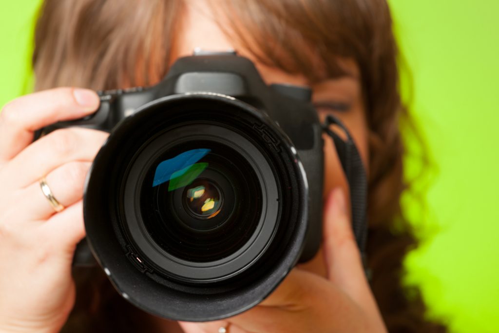 Female photographer taking photos with DSLR digital camera