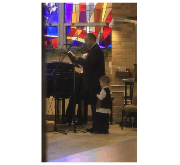 Man cantoring with boy near him
