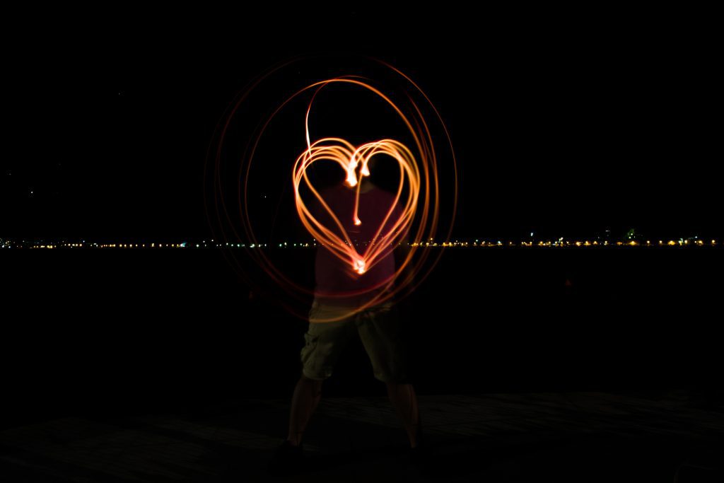 A photo of a man painting heart with light flash