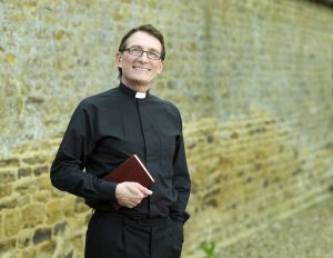 A Priest holding a bible