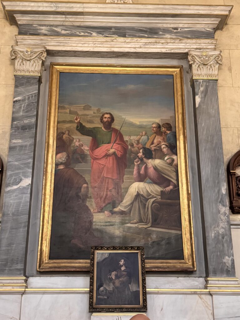 Painting of St. Paul preaching to a seated crowd, in a gilded frame
