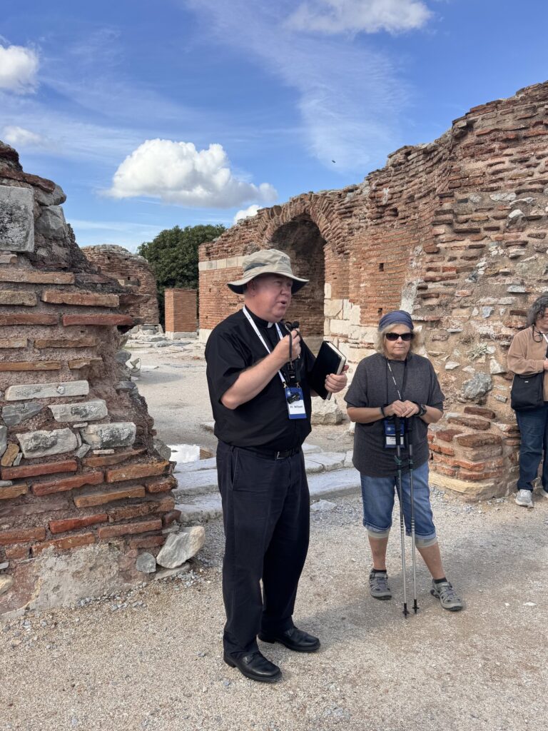 Fr. Jonathan Wilson speaking to pilgrims among the brick ruins of the Church of Mary