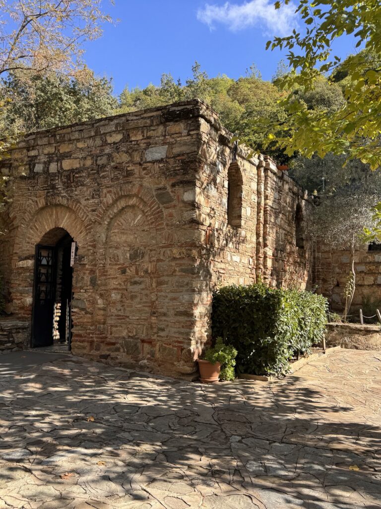 The small stone House of the Virgin Mary among trees on the hill above Ephesus