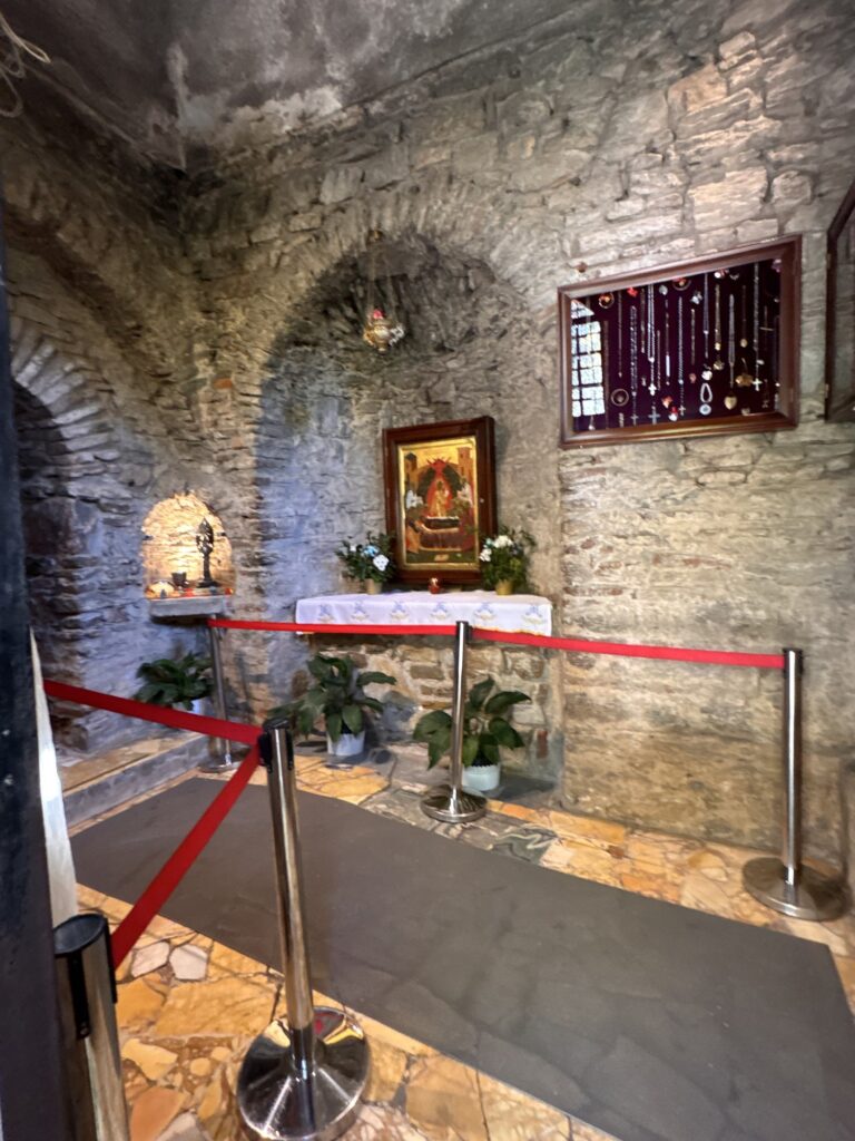 The small stone chapel inside the House of Mary, with an icon and an altar behind a rope