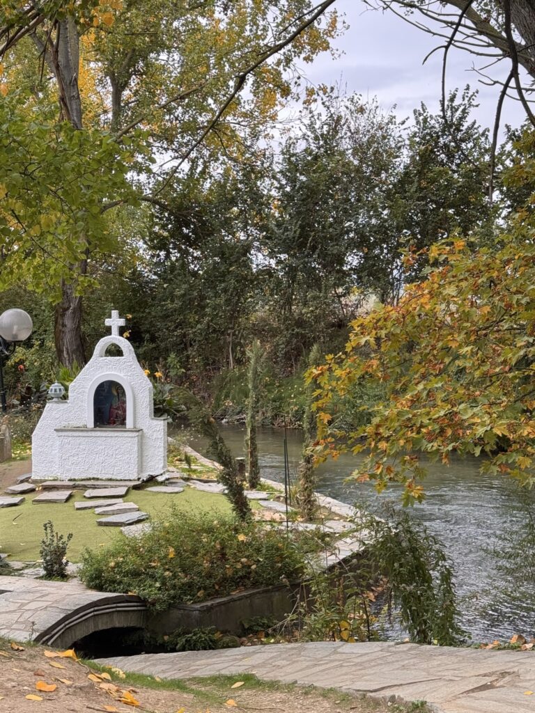 A small whitewashed shrine topped with a cross beside the river at the baptistery of St. Lydia