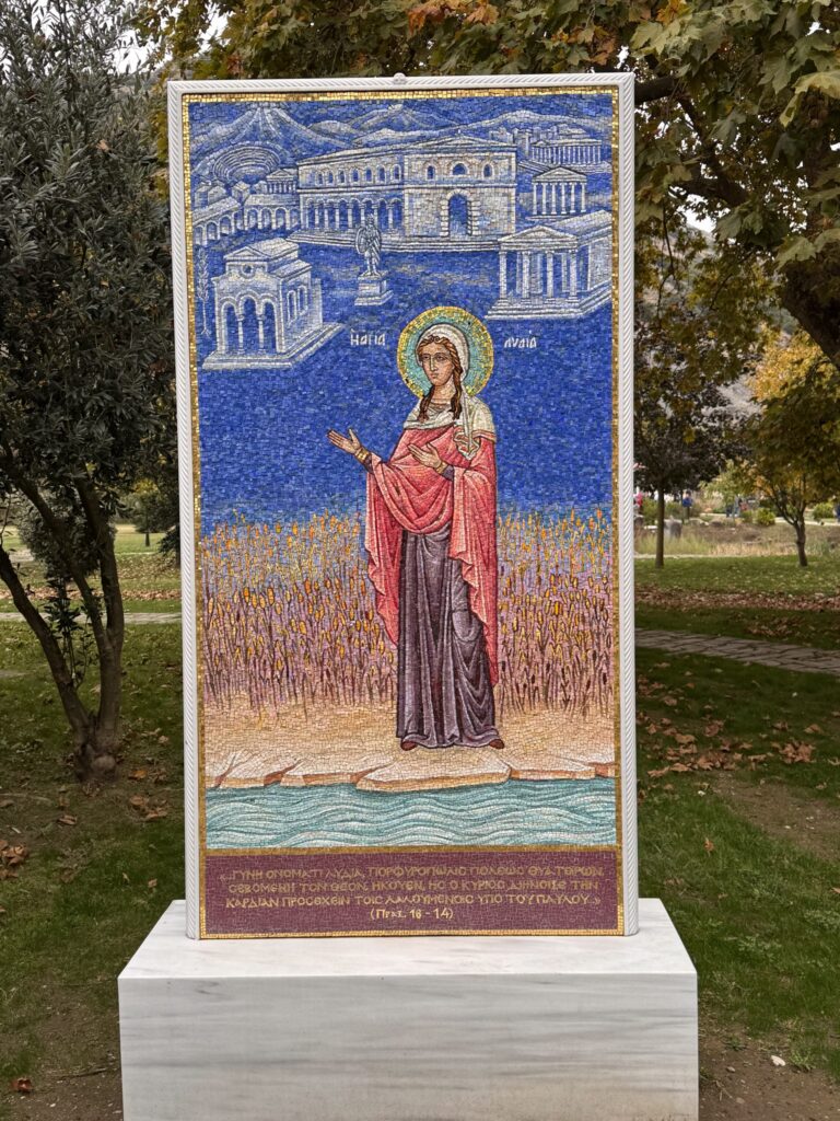 A mosaic of St. Lydia standing by the river, with the text of Acts 16:14 in Greek