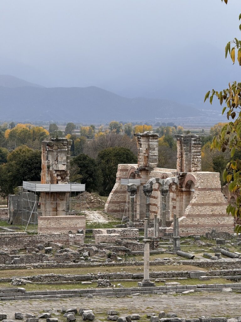 The pillars of an early Christian basilica rising beyond the forum of Philippi, with mountains in the distance