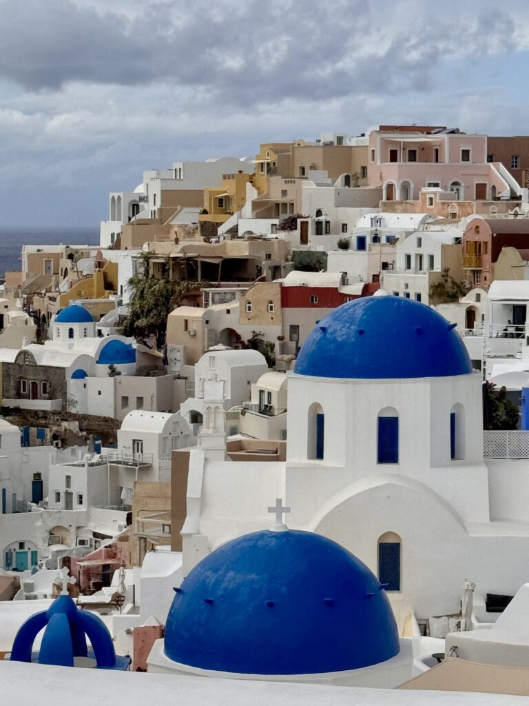 Blue church domes among whitewashed houses on the cliffs of Santorini