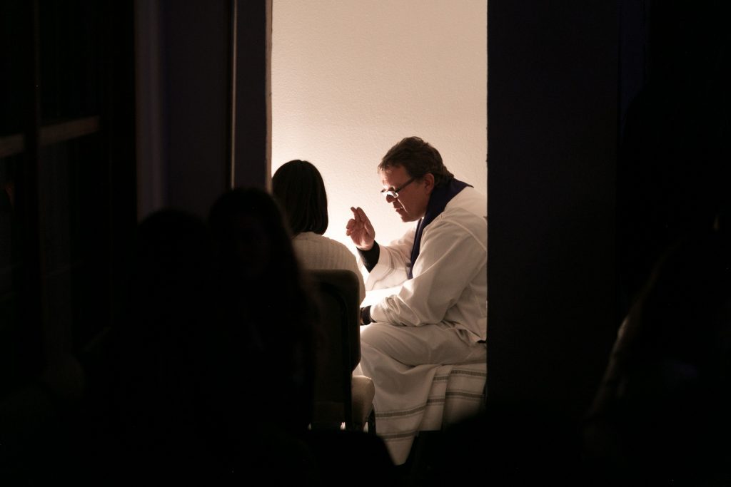 Priest granting absolution during Confession