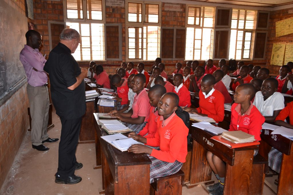 priest talks to students in classroom