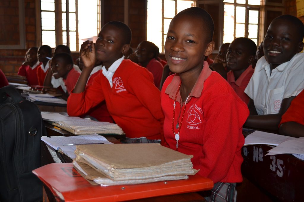 students in red uniforms sitting at desks