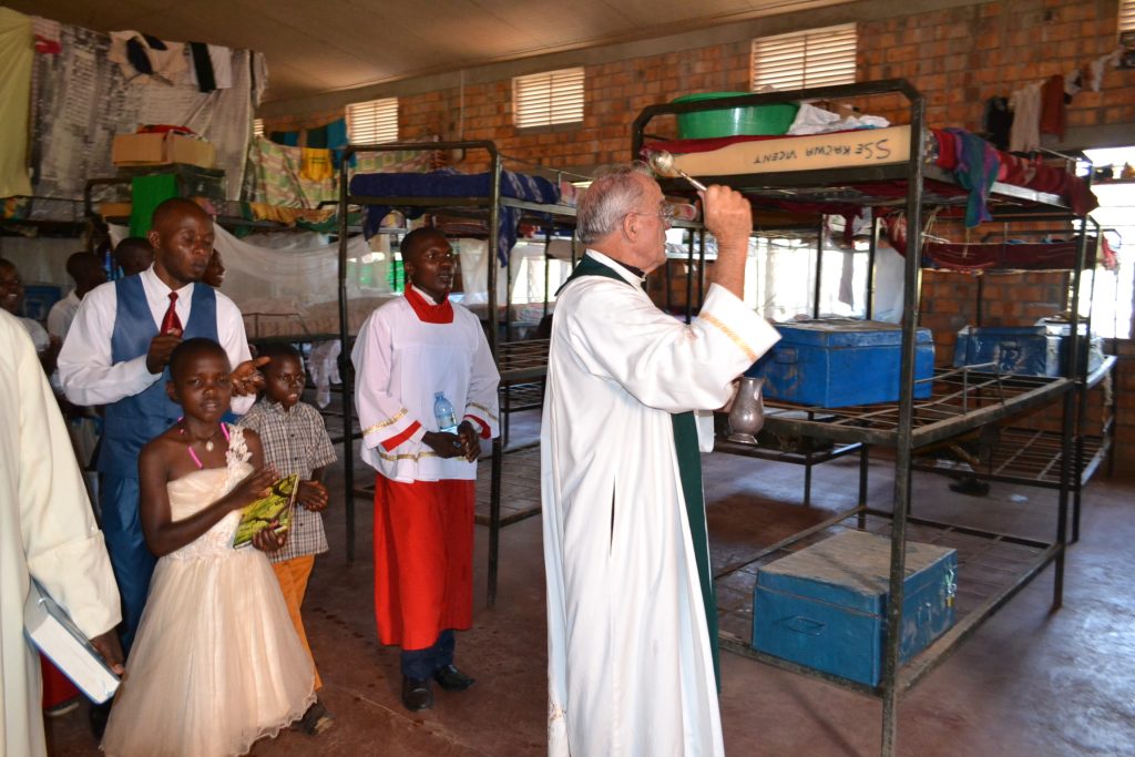 priest blesses dorm room beds