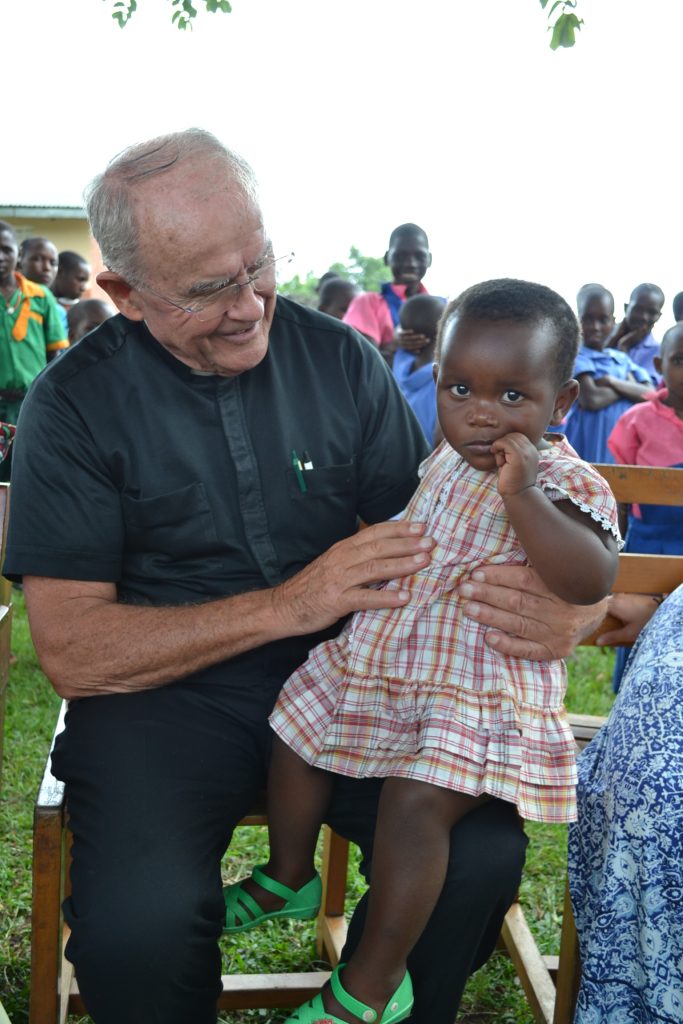 man wearing black with young child on knee