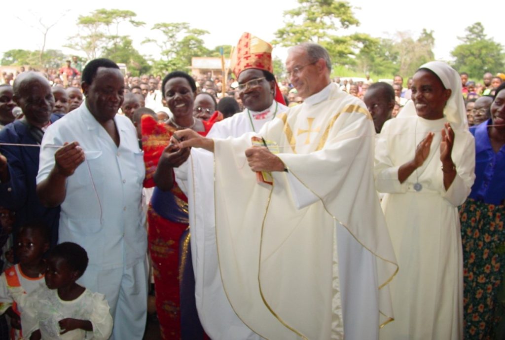 priest cuts string with crowd looking on