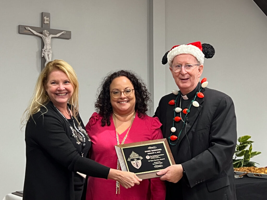 Doris Quiñones receives service award from Kimberlee Riley and Bishop Noonan