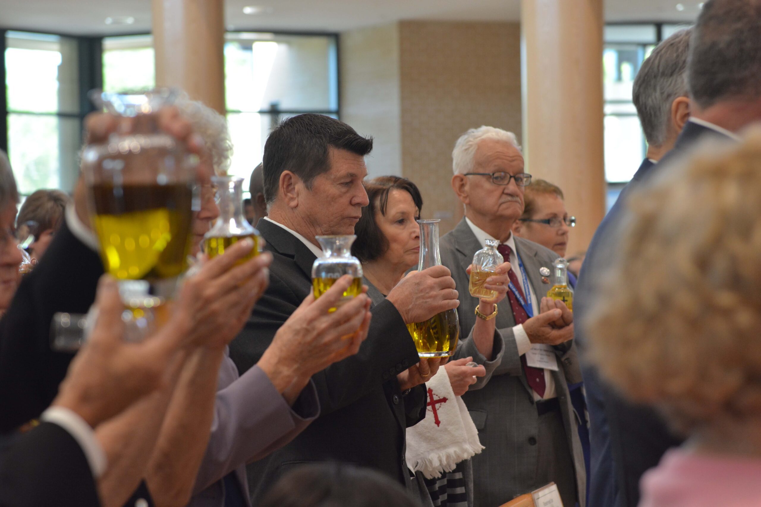 Parish representatives holding their parish’s Oil of Catechumens as it is blessed. Photo credit: Maria Mertens.