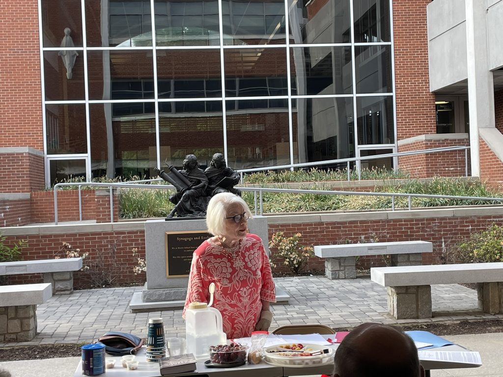 Queenie Ross speaking to Faith in Action members outdoors at Marist School