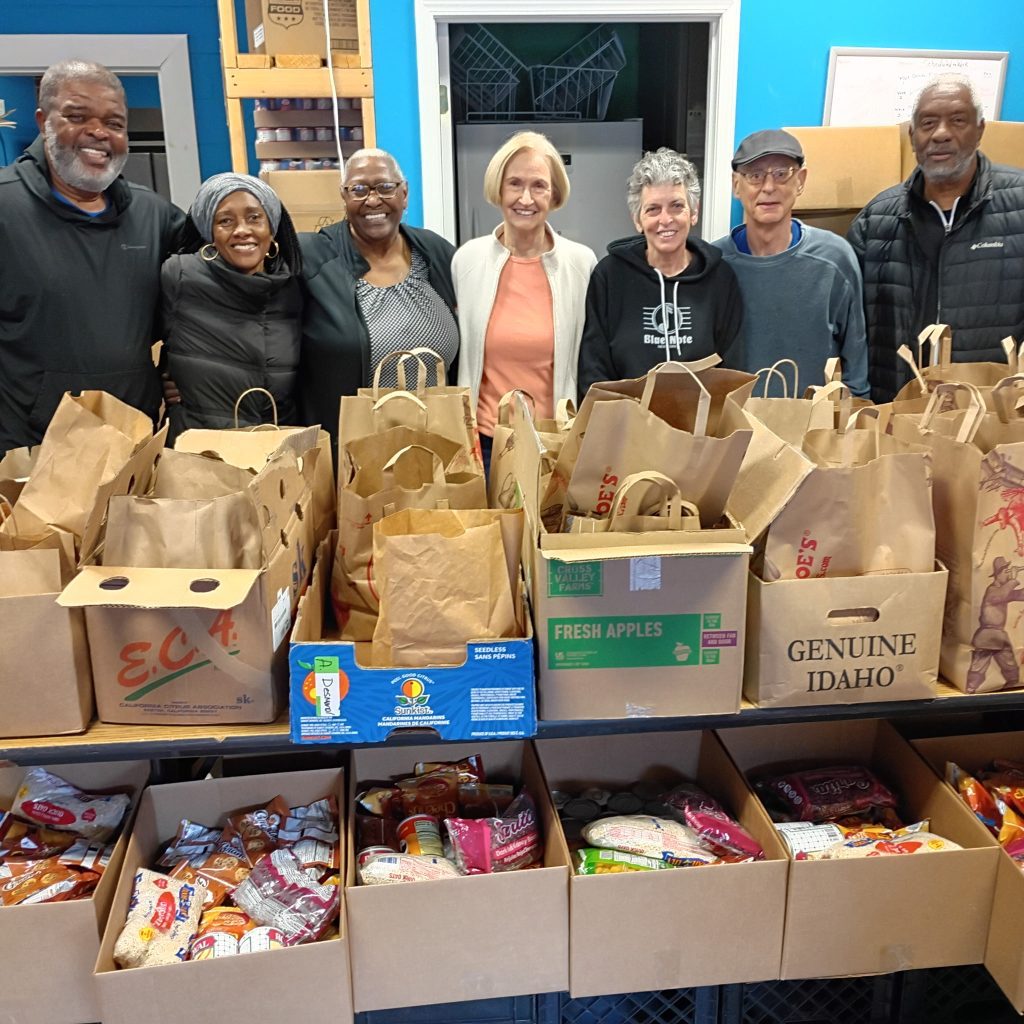 Faith in Action volunteers with bags and boxes of food at the Sts. Peter and Paul pantry