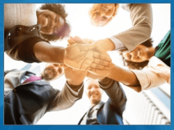 Group of five people with their hands in.
