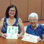 Left to right: Sue Shanks, Diane Schneider, Mary Lauritz, and Lynne Hall with SJB School Yearbooks