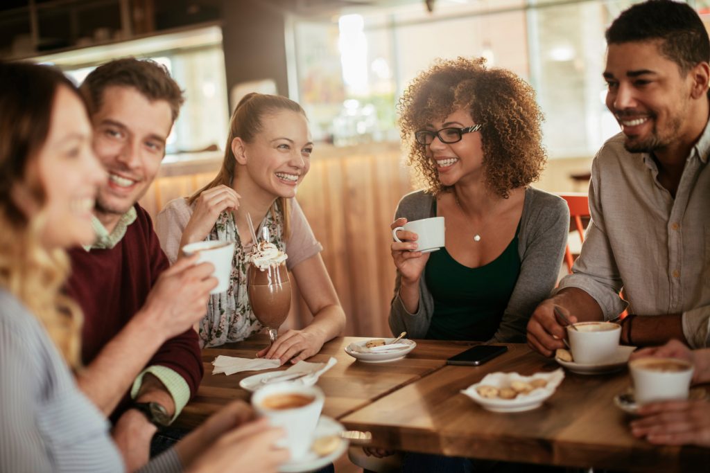 friends smiling and sitting in a cafe