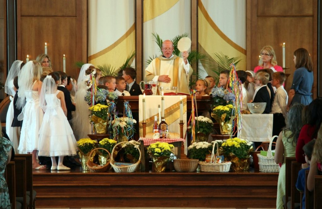 Father holding up the large host