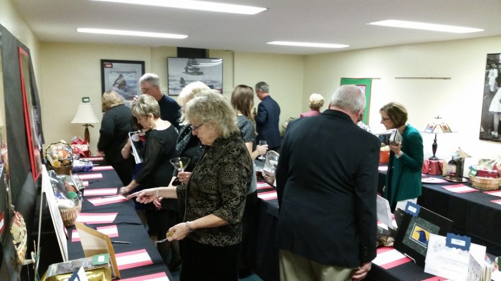 Auction attendees perusing items in an auction room.
