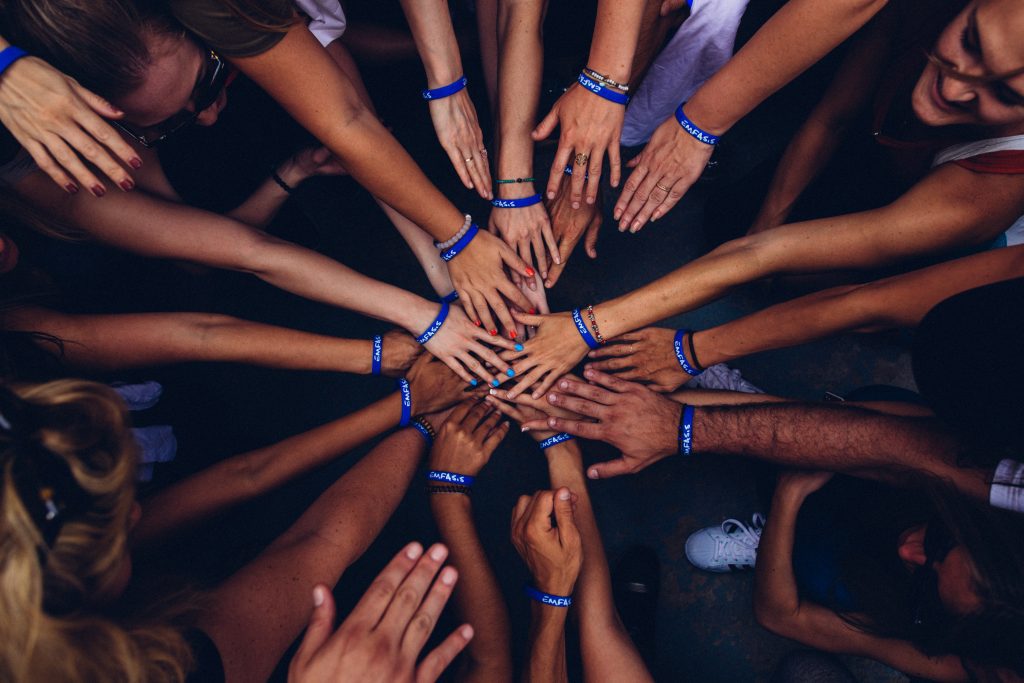 Hands brought together in a huddle