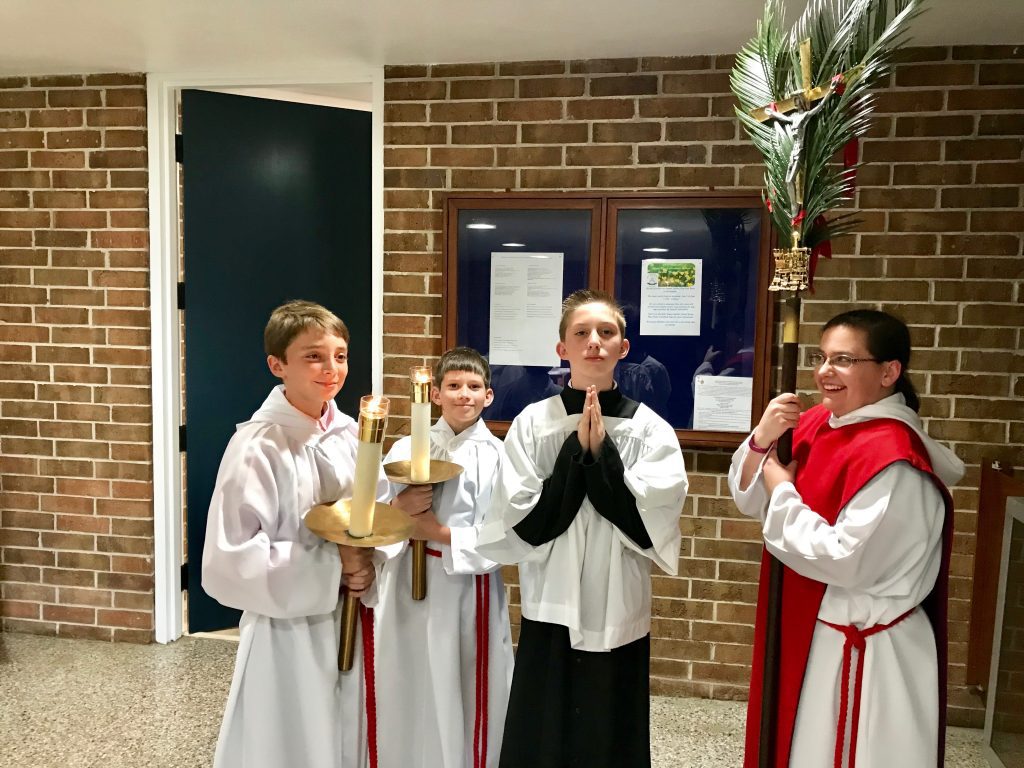 Altar servers with candles and crucifix