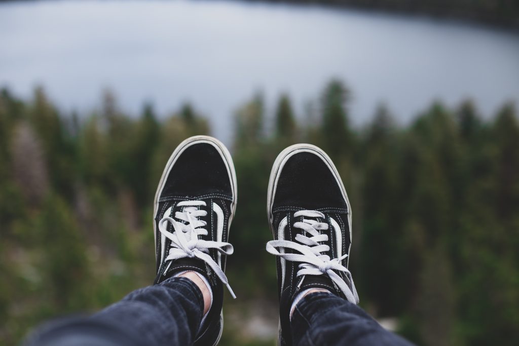 Person feet with lake and forest in the background