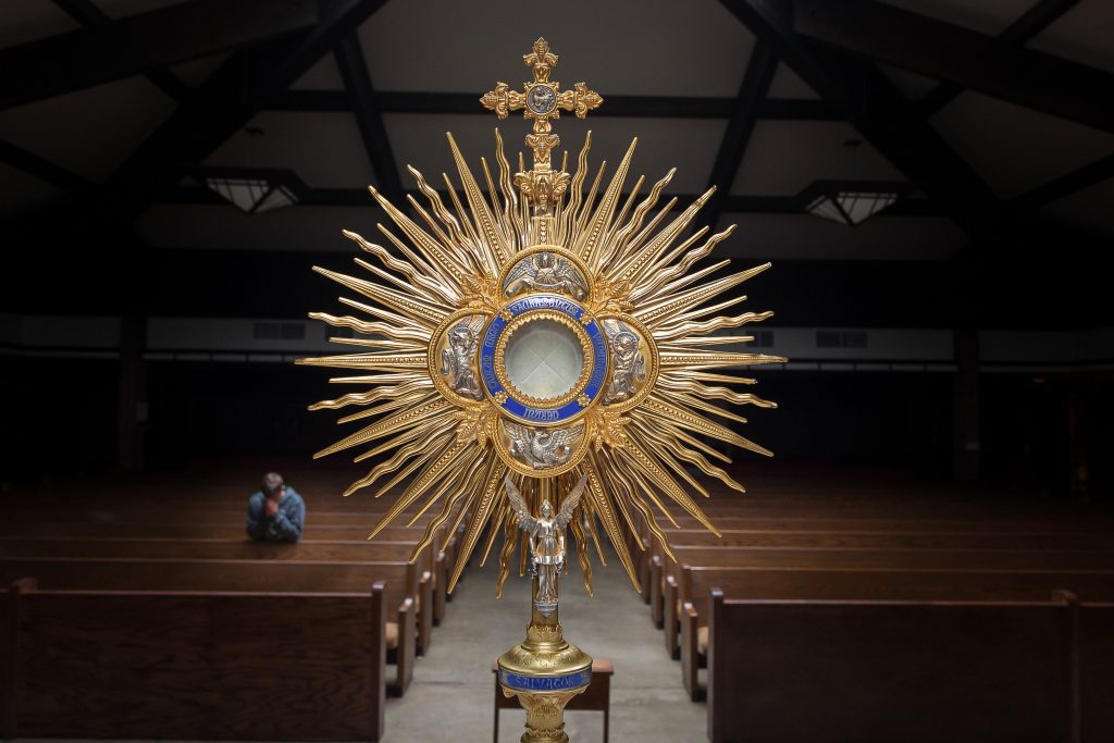 Monstrance with man in prayer