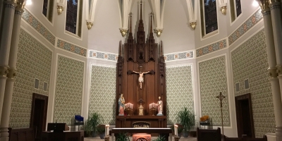 sanctuary and altar with tabernacle and candles in front of crucifix